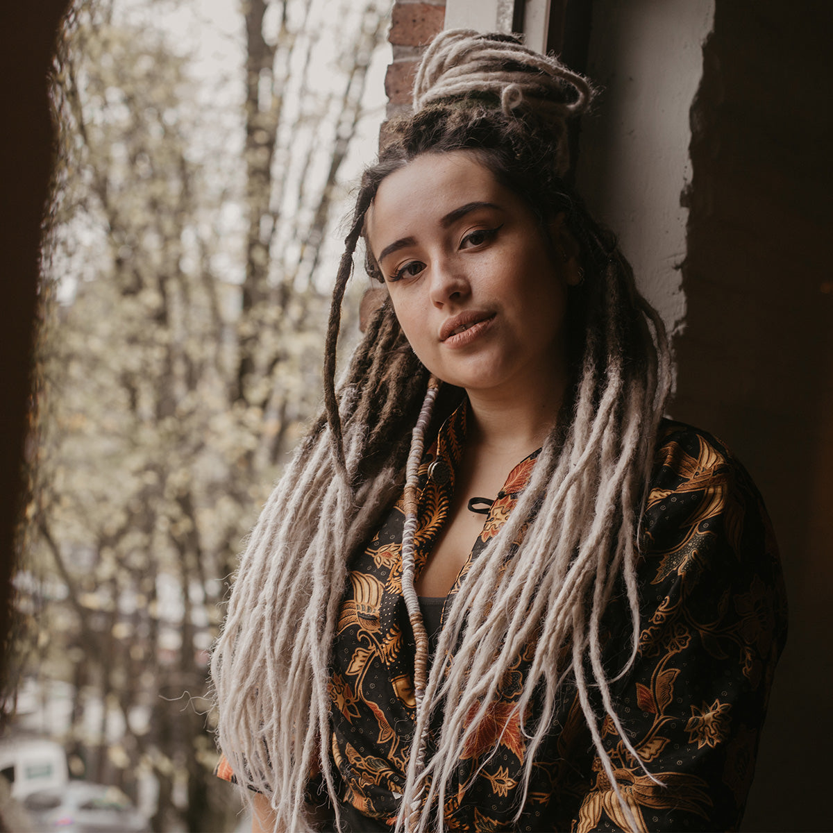 Romy in the window with chocolate swirl dreads, Are synthetic dreads harmful for your hair? 