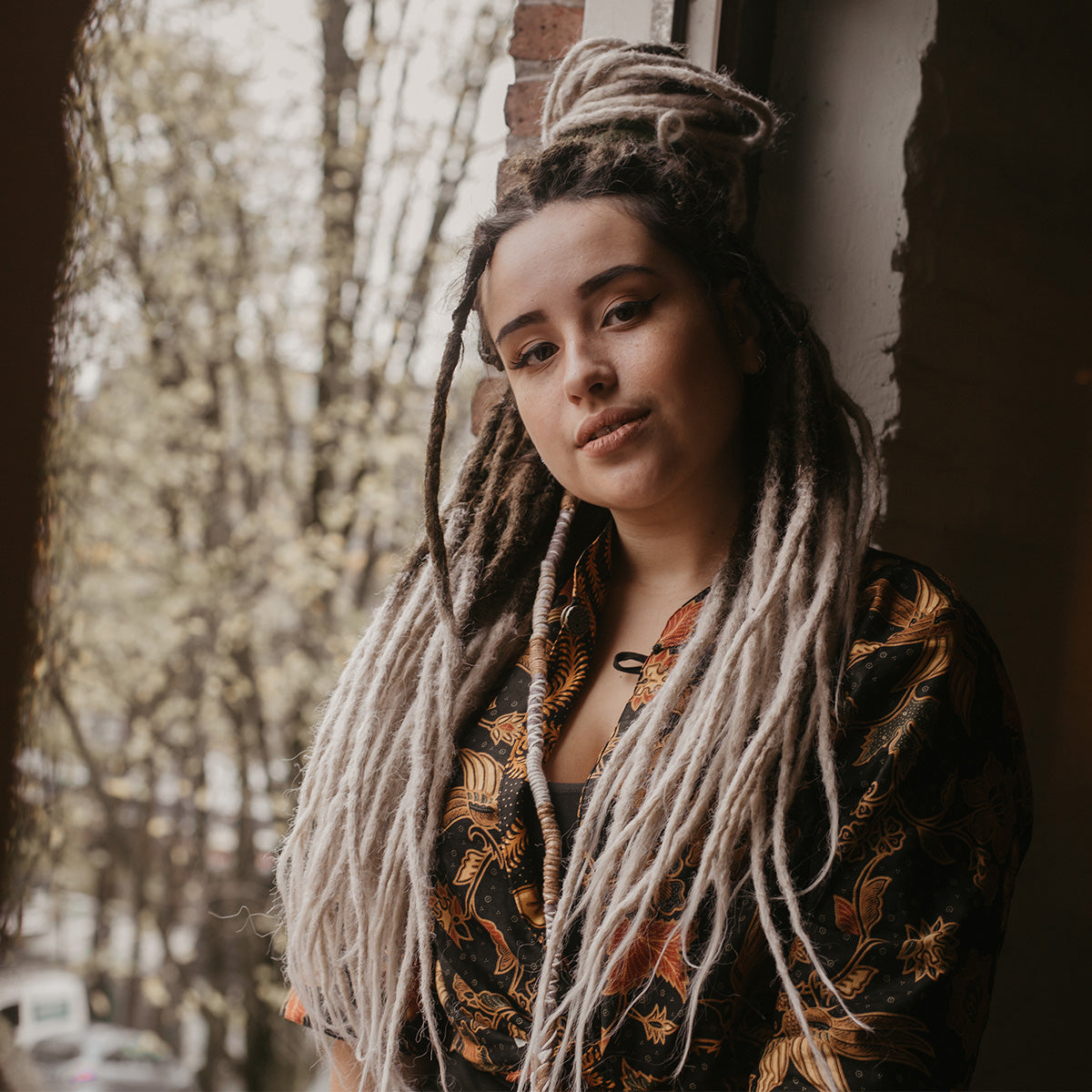 Romy in the window with chocolate swirl dreads, Are synthetic dreads harmful for your hair?