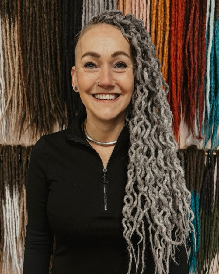 Dreadshop Salon customer withcurly partial dreadlock extensions in gray color with shaved sides
