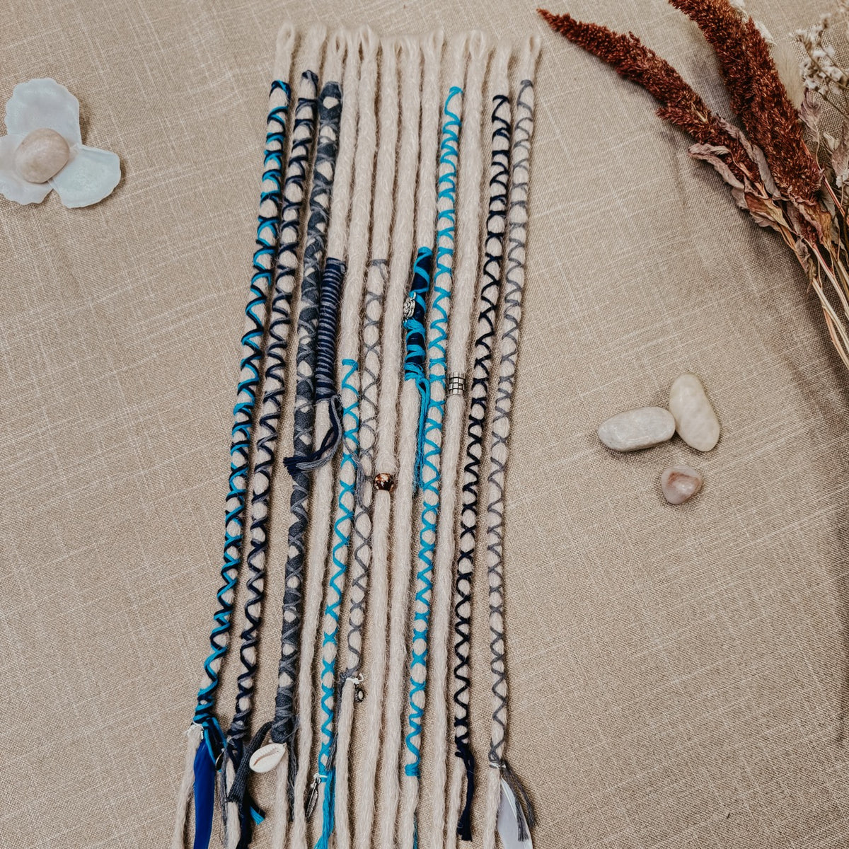 Decorated Dreadlock Extensions: ash blonde, white silver dreads with blue and gray decorations. Accent Set from Dreadshop.