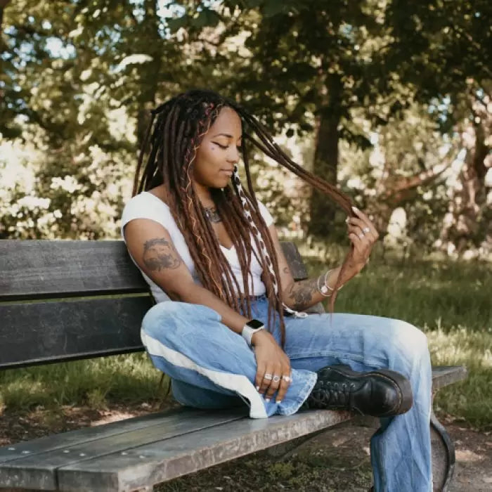 Gin sitting on a bench in the park wearing the dreadset Oaky  in Bum length, Dreadset Locks of Love Shop the look, dreadset full head, Dreadset original locks of love