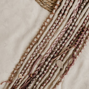 Decorated Dreadlock Extensions: ash blonde, white purple, plum decorations. Accent Set from Dreadshop. Close up on the middle