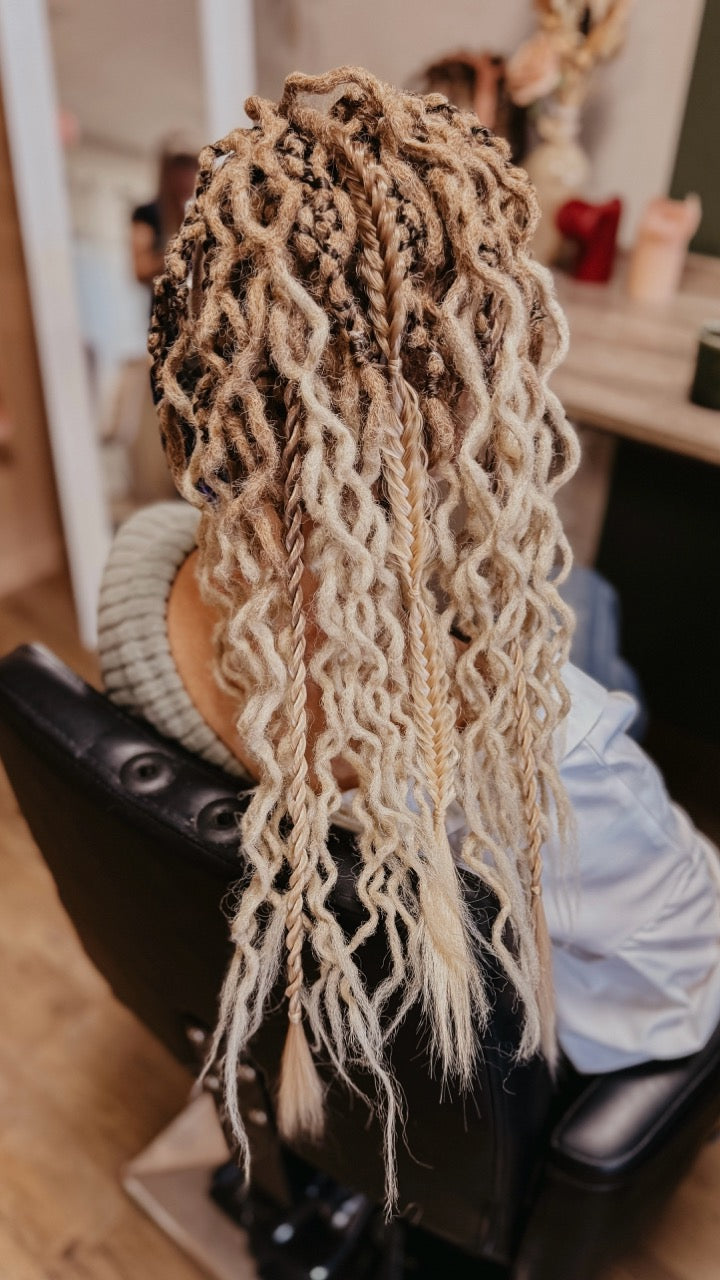 Dreadshop Salon customer with curly partial dreadlock extensions in natural blonde ombre colors with shaved sides and extra braids