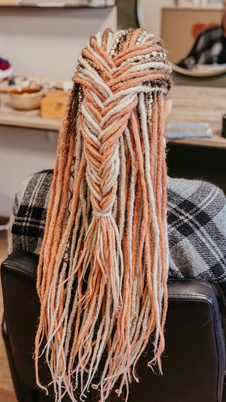 Back view of a customer from Dreadshop Salon with Pink and Blonde Dreadlock Extensions installed 