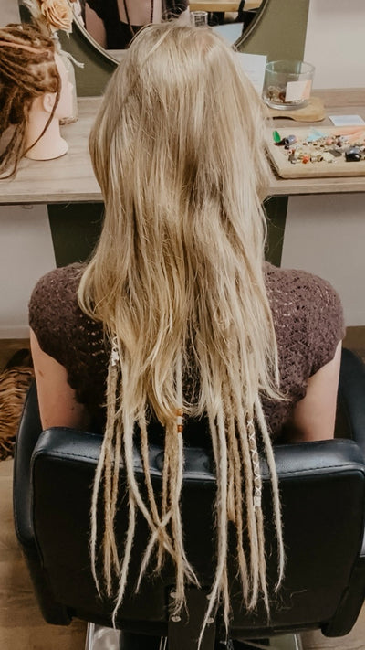 Partially braided dreadlock extensions. Dreadshop Salon customer. Short blonde hair with longer dreadlocks