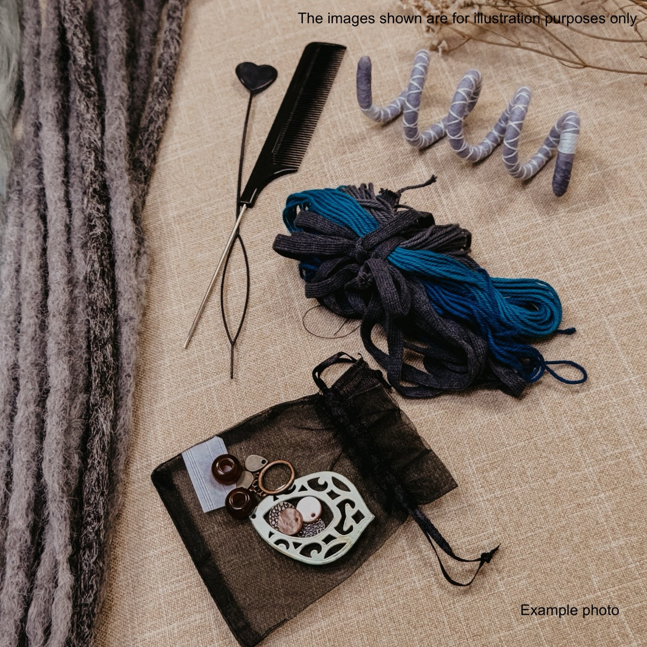 A styled flat-lay of jewelry-making supplies on a beige linen surface, including a black comb, metal findings, a coil of gray and blue yarn, and a small black mesh pouch with earrings, alongside a textured gray fabric strip on the left.