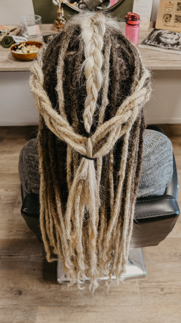 Person with Real Dreadlocks, part of the hair is left loose and braided into an updo | Dreadshop Salon