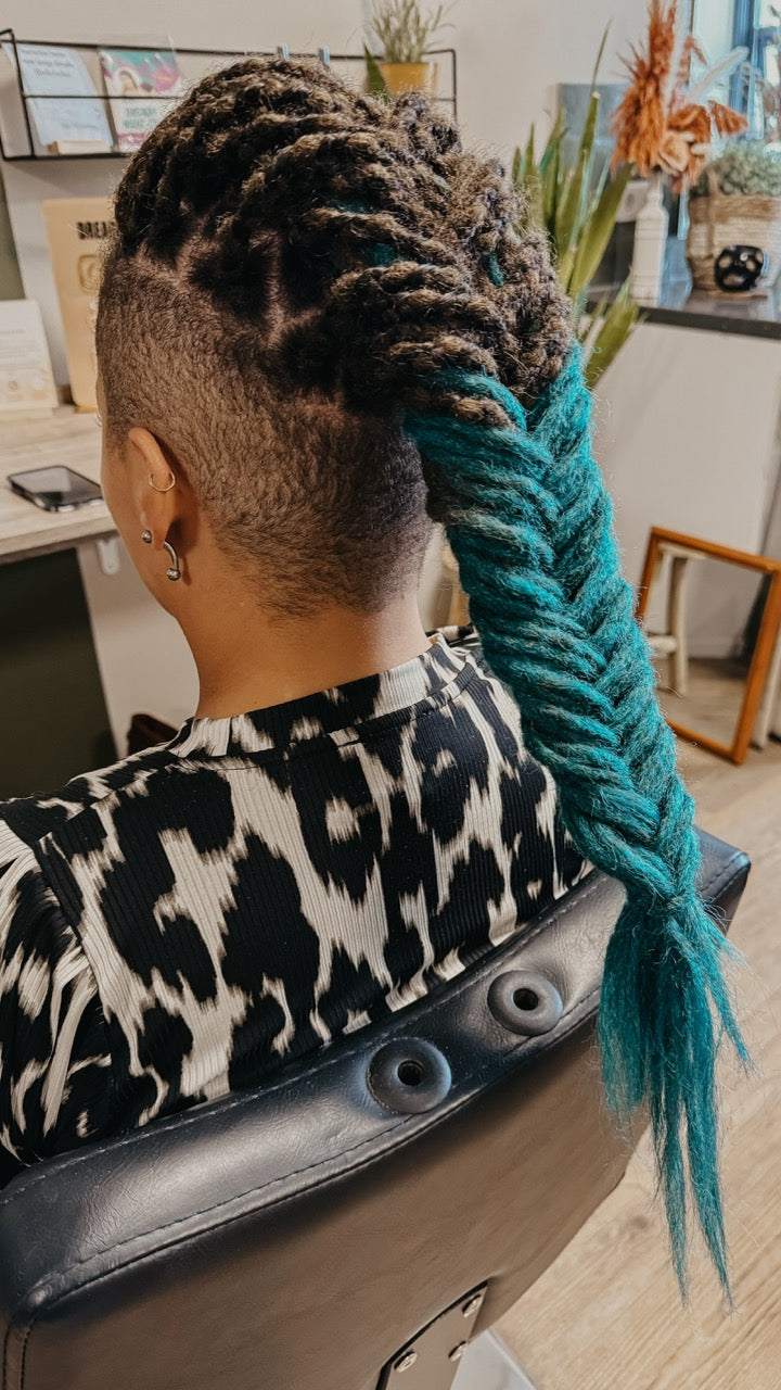 Dreadshop Salon customer with partial dreadlock extensions in teal and brown ombre colors with shaved sides