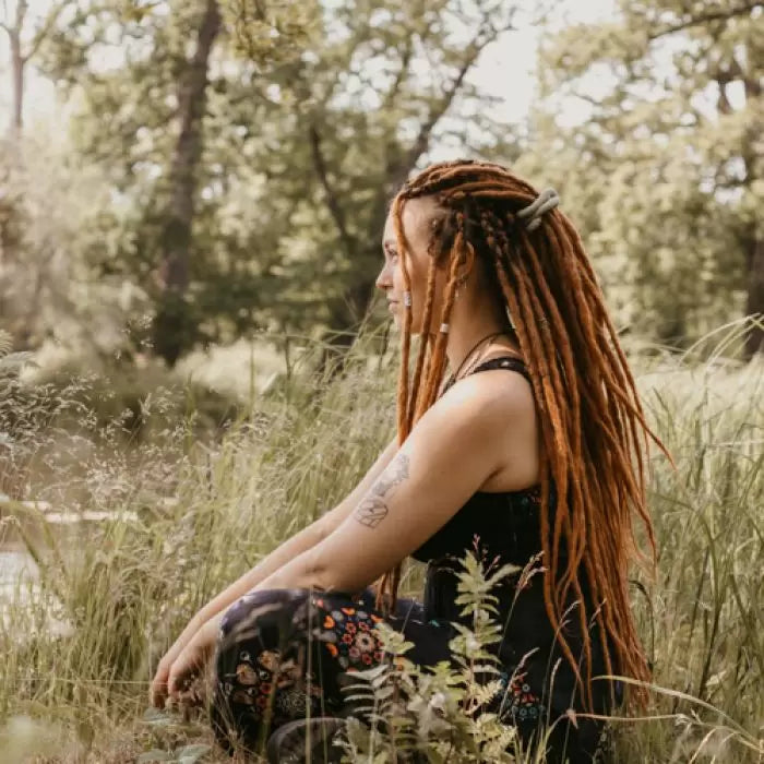 Romy from the side sitting in the grass wearing the dreadset Go ginger in Bum length, Dreadset Locks of Love Shop the look, dreadset full head, Dreadset original locks of love 
